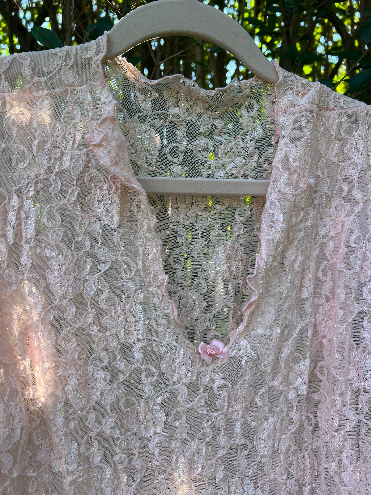 A pale pink lace top with a ruffled V-neckline vintage